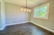 empty room with 4 light chandelier, wooden floor and large window