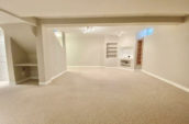 large carpeted room leading to staircase