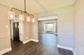 hallway with a 4 light chandelier leading to two rooms