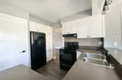 kitchen showing double sink, electric oven and fridge/freezer